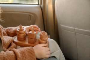 Kind speelt met een houten reisspeeltje